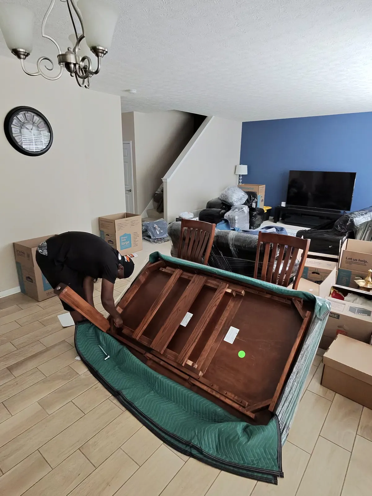 ASAP Moving crew member working on an upside-down table resting on a moving blanket in Avon Lake.